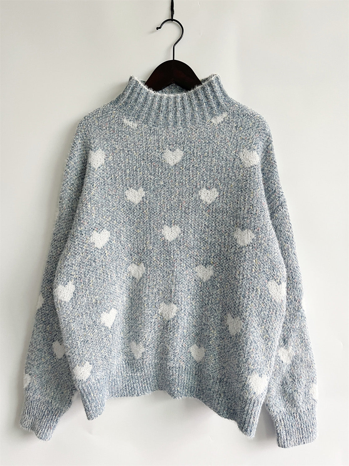 Mint blue acrylic turtleneck sweater with all-over white heart motif.