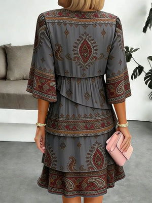 Paisley print tiered mini dress in dark gray with ruffle details and bell sleeves.