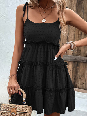 Black dotted swiss tiered mini dress with tie straps and ruffled tiers.
