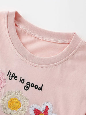 Pink cotton t-shirt with embroidered flowers and "life is good" text.