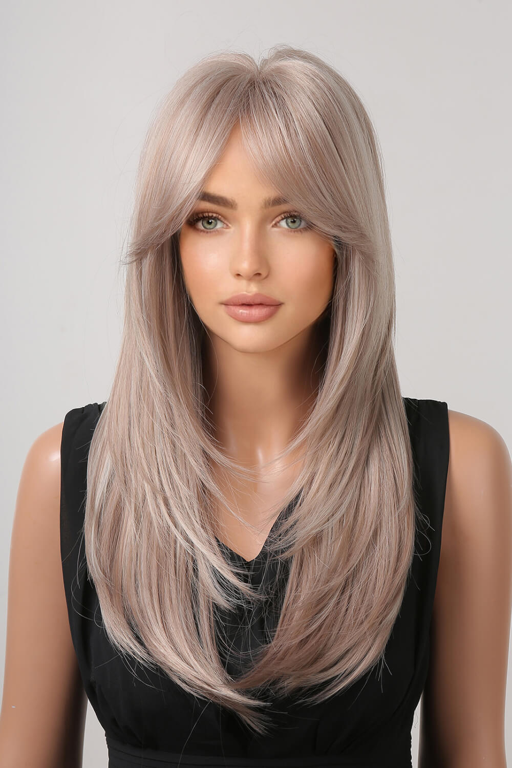 Layered synthetic wig in Blonde/Light Brown with bangs and face-framing layers.