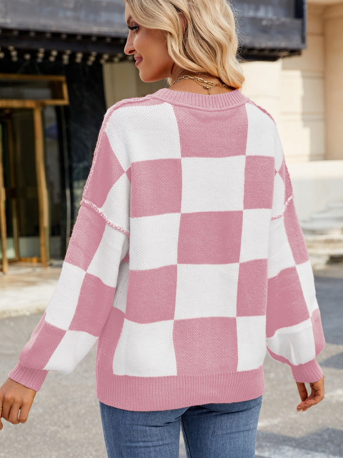 Checkerboard knit sweater in blush pink and white with balloon sleeves.