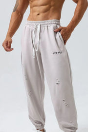 Gray distressed joggers with Gym Bull logo and drawstring waist.
