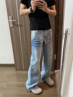 Men's light wash wide-leg jeans with distressed details and a chain accent.