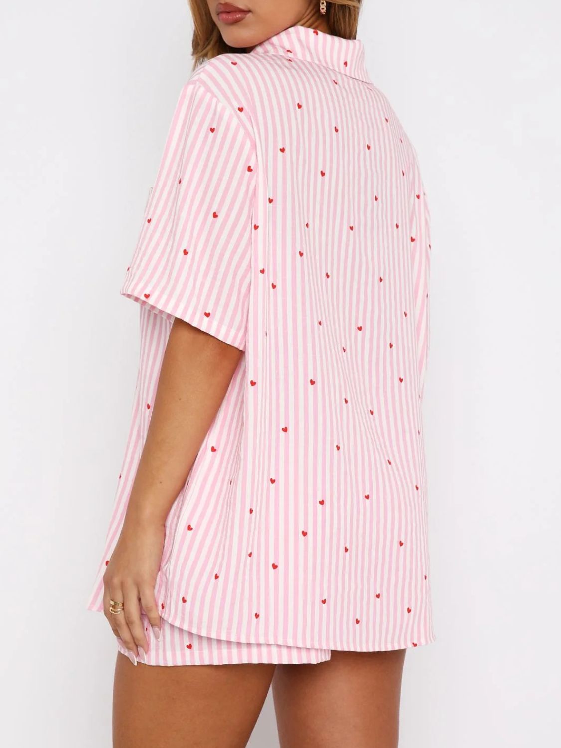 Blush pink striped pajama set with red hearts, collared button-up top and shorts.