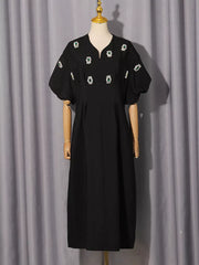 Black midi dress with puff sleeves and rhinestone embellishments.