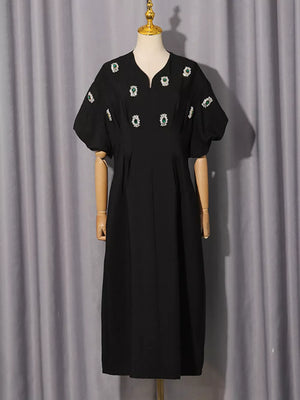 Black midi dress with puff sleeves and rhinestone embellishments.