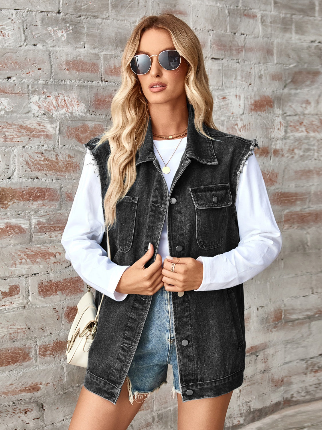 Black raw-edge denim utility vest with button front and chest pockets.