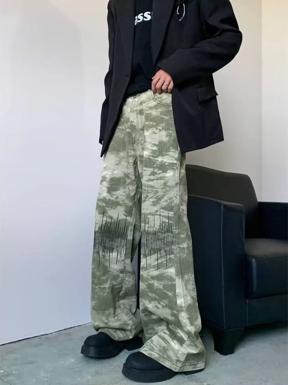 Abstract print wide-leg jeans in green camouflage with black graphic detail.