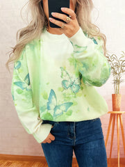 Lightweight knit sweater with a green watercolor butterfly print and rhinestone details.