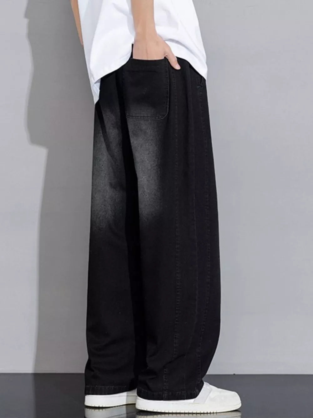 Relaxed fit black denim jeans with wide legs and vintage wash detail.