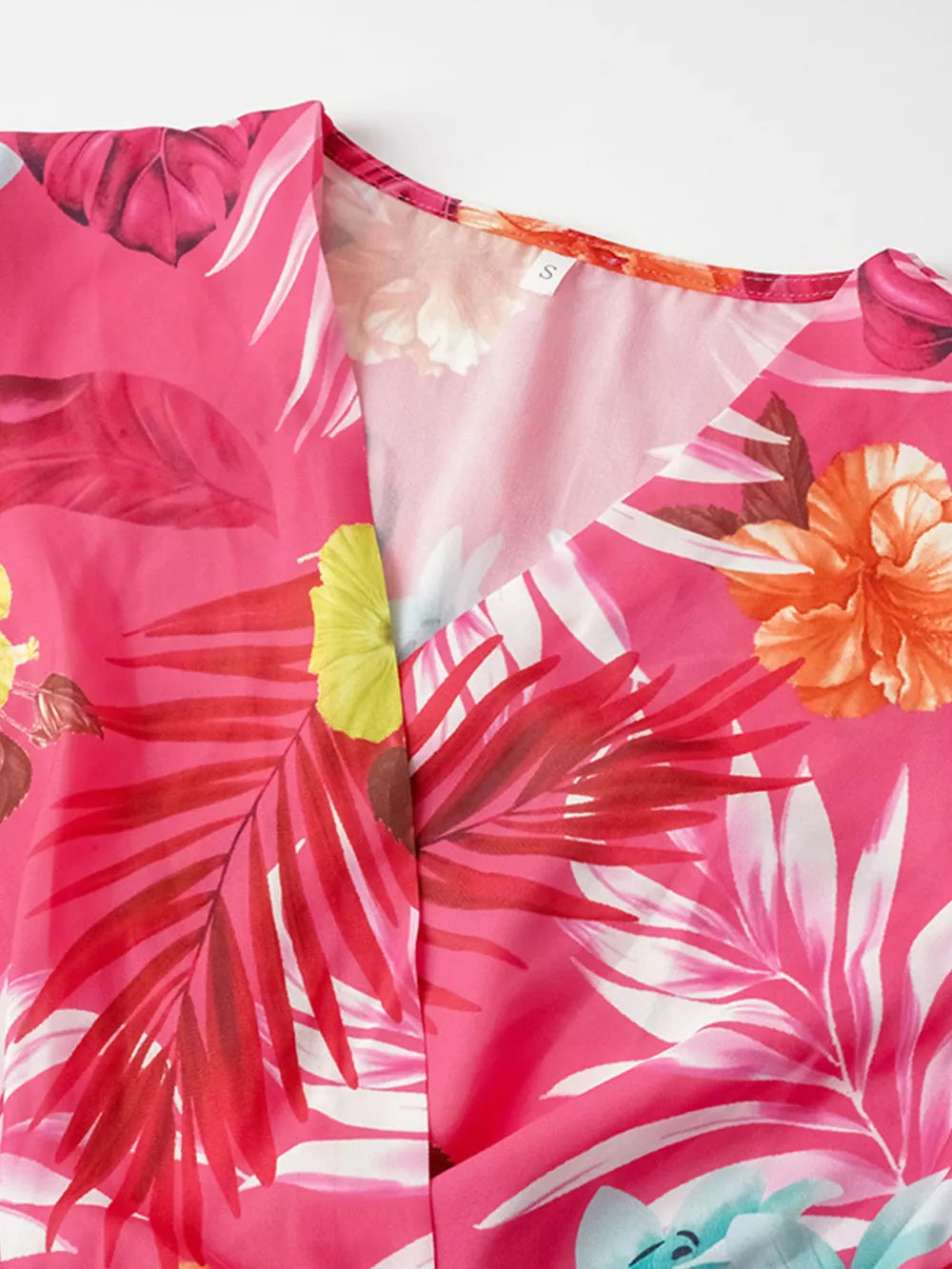 Hot pink tropical print midi dress with V-neck and pleats.