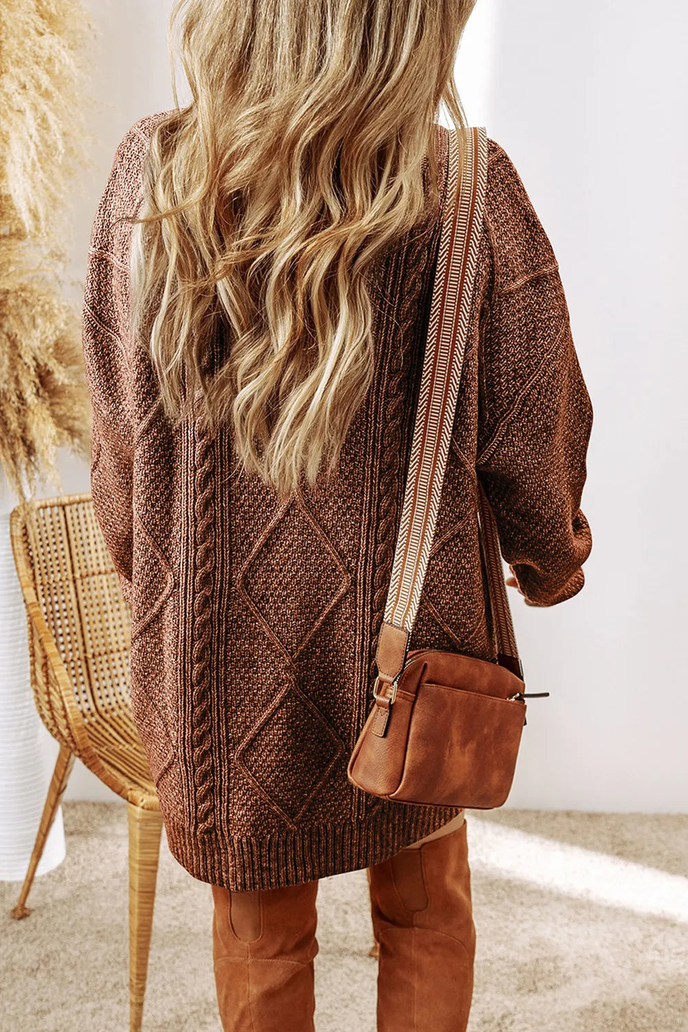 Cable knit diamond sweater dress in brown with a crossbody bag and suede boots.