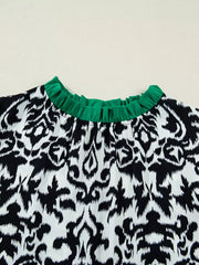 Damask print maternity blouse with ruffled green neckline and half sleeves.