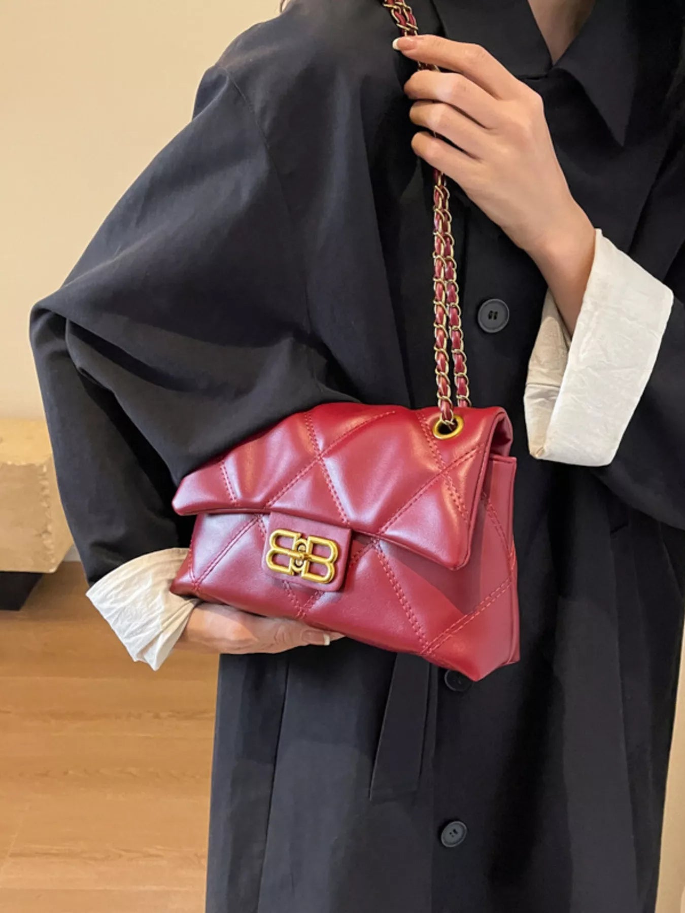 Red quilted flap chain shoulder bag with gold hardware and a turn-lock closure.