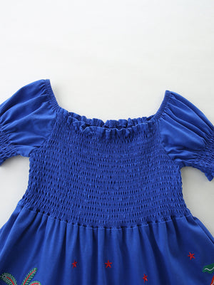 Blue cotton baby dress with smocked bodice, puff sleeves, and jungle print detail.