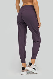 Plum purple jogger fit performance trousers with pockets and cuffed ankles.