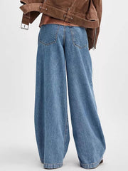 Pleated wide-leg denim trousers in dusty blue with a buttoned closure and back pockets.