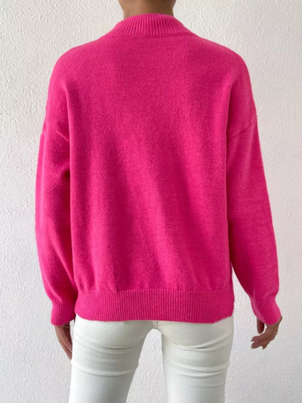 Fuchsia pink mock neck knit sweater with dropped shoulders and ribbed cuffs and hem.