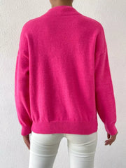 Fuchsia pink mock neck knit sweater with dropped shoulders and ribbed cuffs and hem.