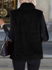 Black fleece zip-up vest with vertical ribbing and a mock neck, layered over a black sweater.