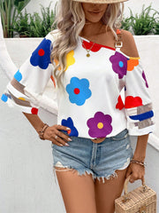White asymmetric blouse with colorful floral print and chain detail on shoulder