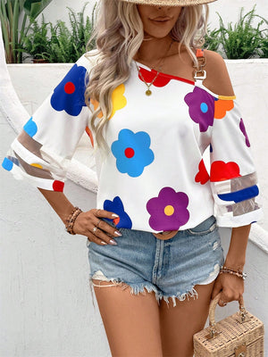 White asymmetric blouse with colorful floral print and chain detail on shoulder