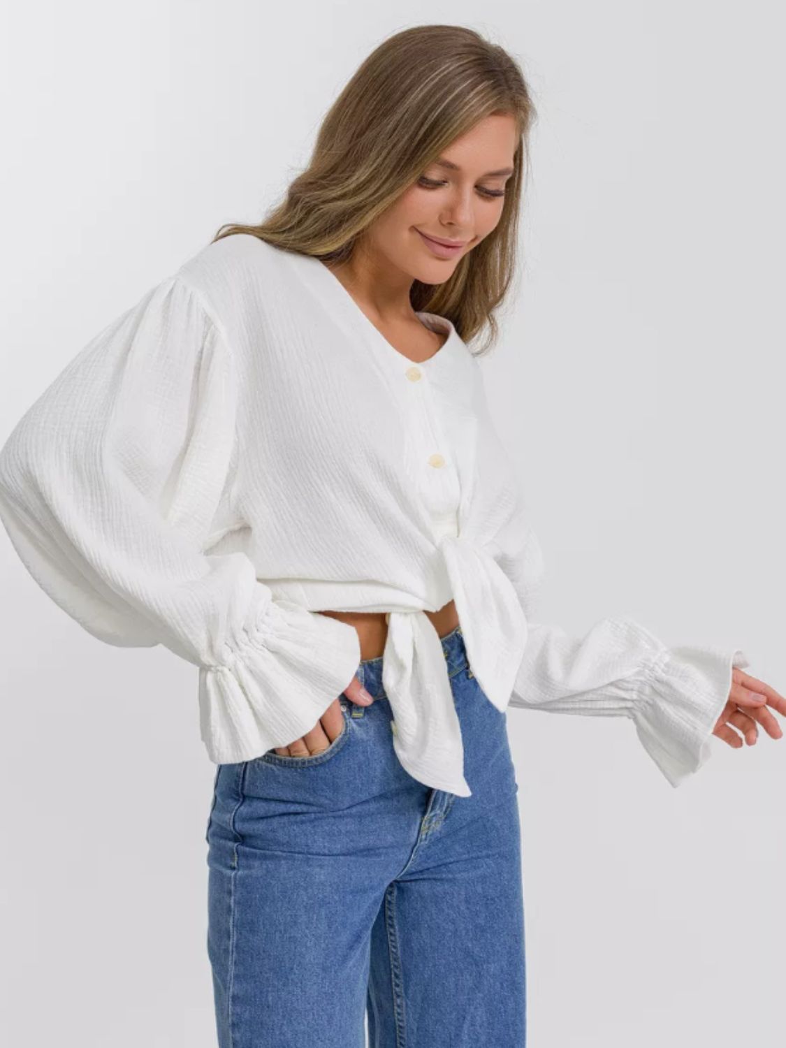 White textured puff sleeve blouse with tie front and ruffled cuffs.