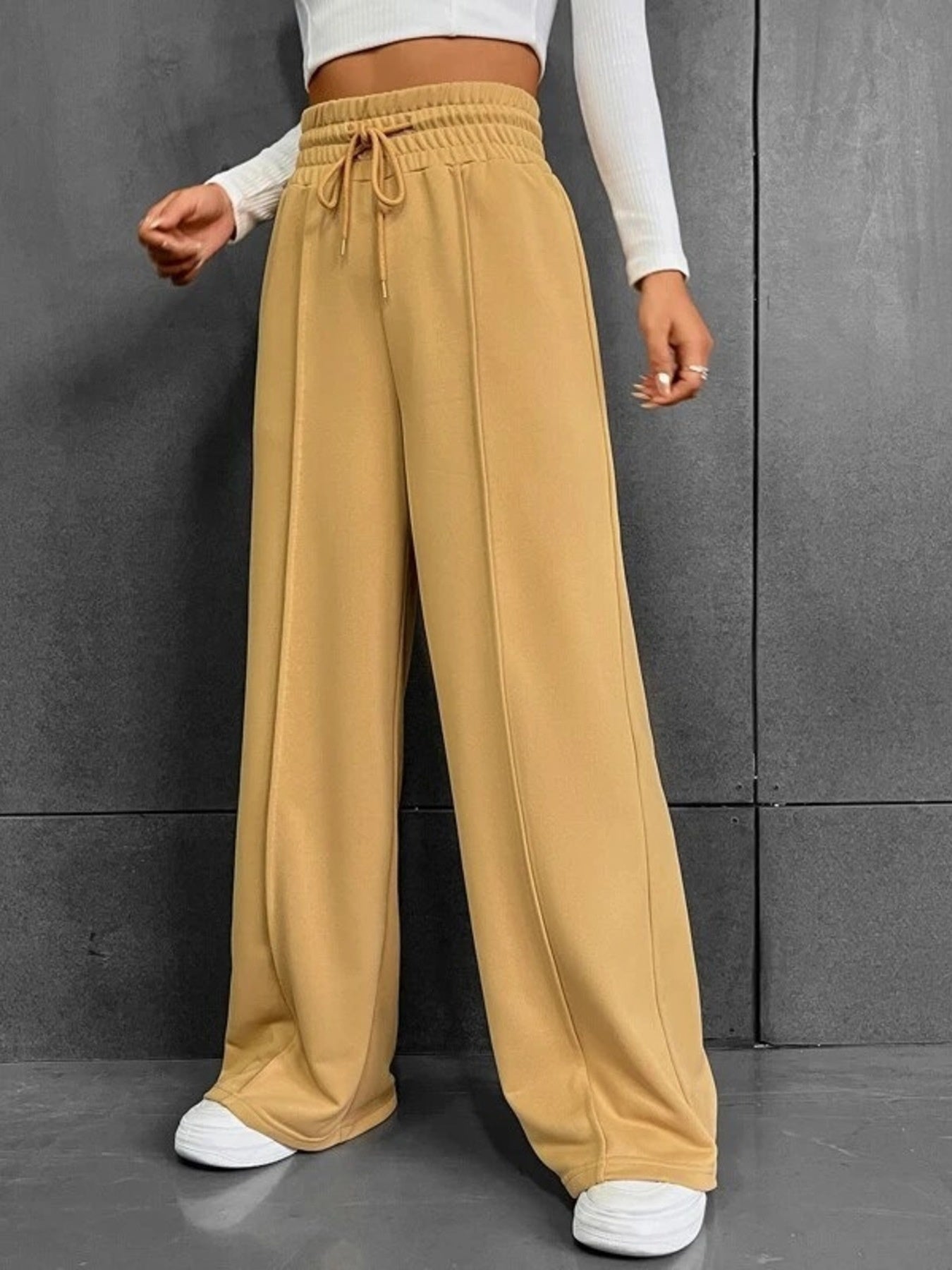 Relaxed wide-leg sweatpants in gold with drawstring waist and front seam detail.