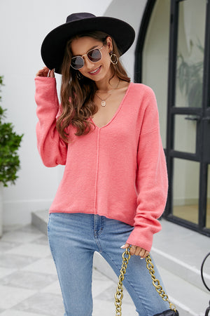 Fuchsia pink fluffy knit sweater with plunging neckline and long sleeves.
