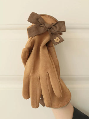 Camel suede gloves with a brown bow detail and charm.