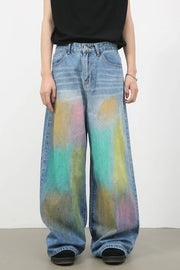 Graffiti wash wide leg denim trousers in medium with colorful abstract paint splatters.