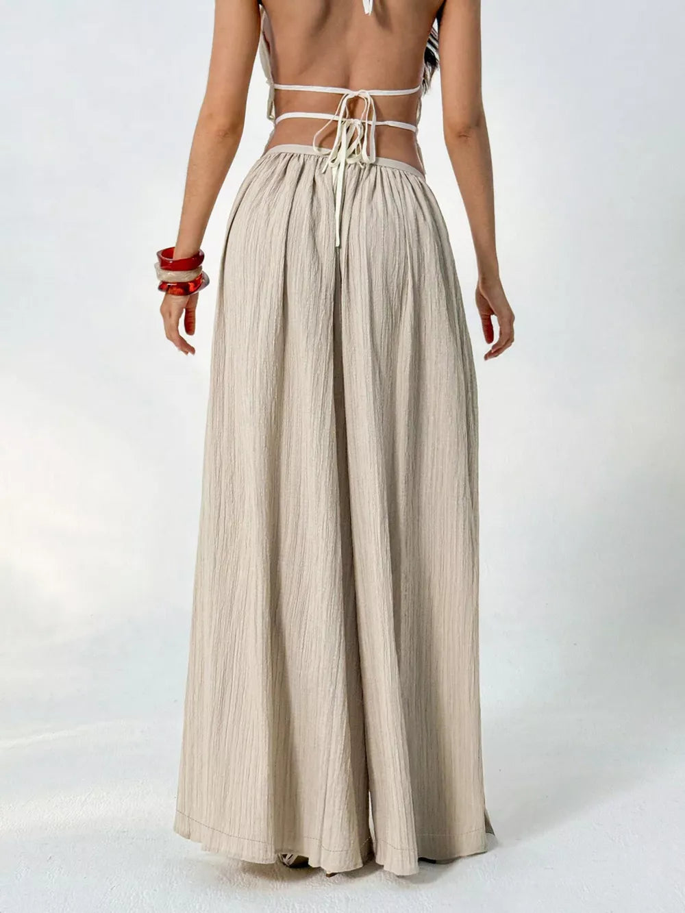 Textured wide-leg maternity pants in beige with a gathered waist and drawstring detail.