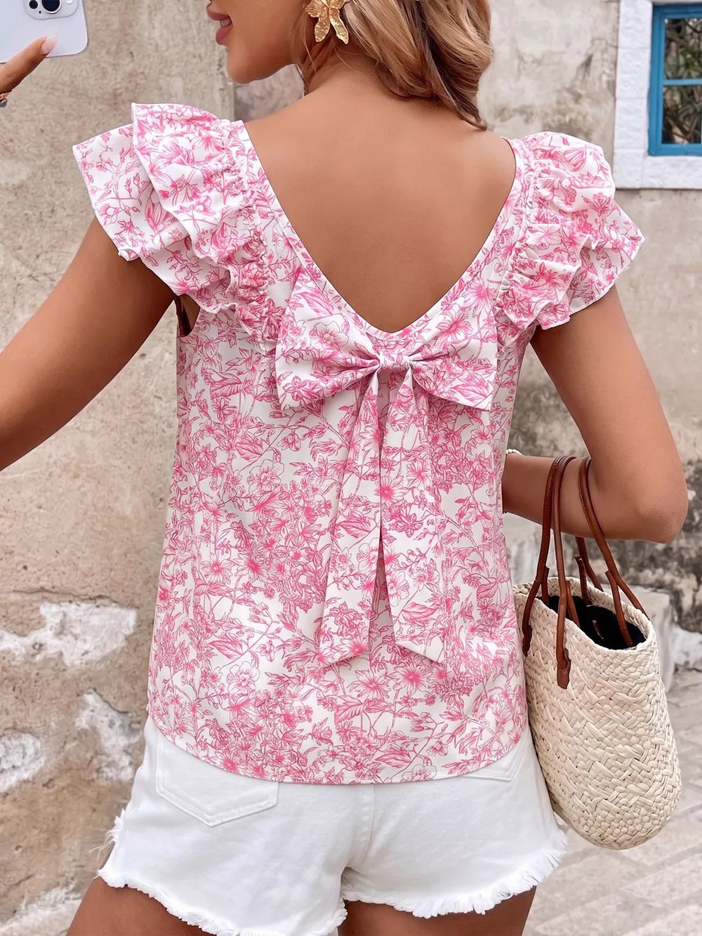 Floral ruffle sleeve maternity shirt with pink floral print and back bow detail.