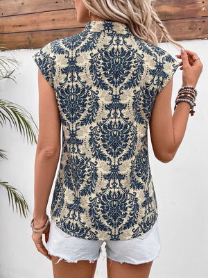 Ornate cap sleeve blouse with notch neckline in a blue and beige damask print.
