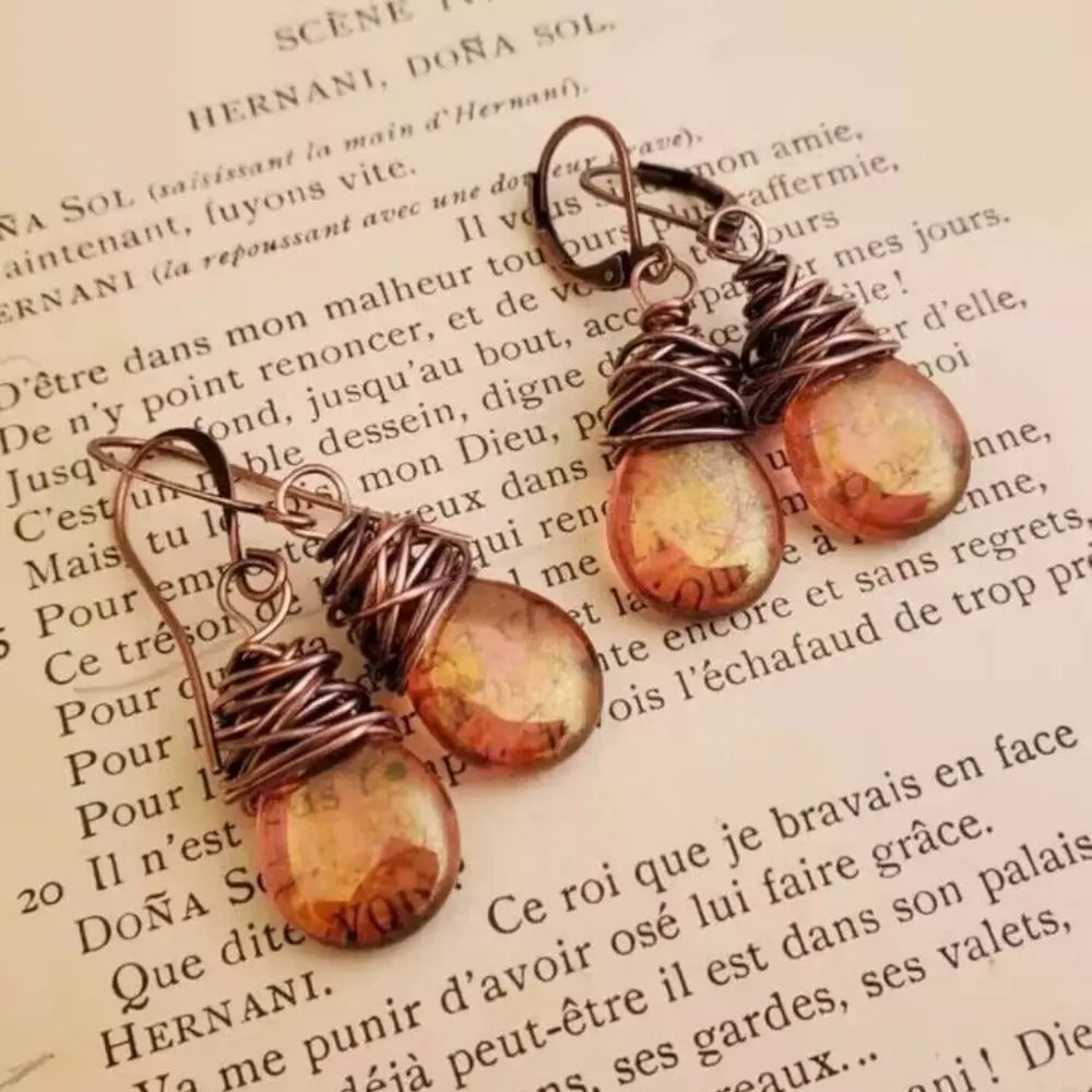 Wrapped wire teardrop earrings with amber iridescent glass beads and copper wire detail.