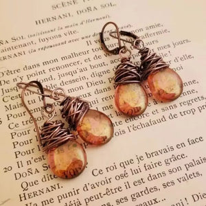 Wrapped wire teardrop earrings with amber iridescent glass beads and copper wire detail.