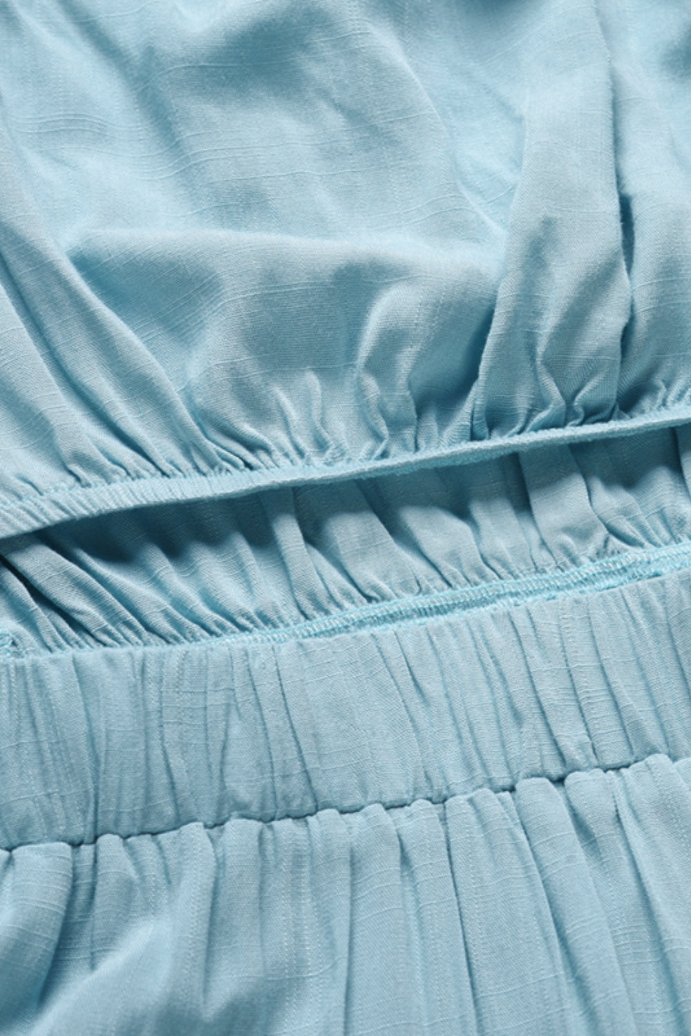 Light blue bandeau jumpsuit detail showing elasticated waist and textured fabric.