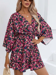 Floral ruffle hem mini dress in black with pink and blue flowers, featuring a V-neck and bell sleeves.