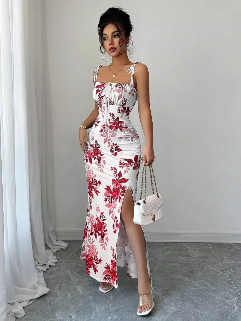 Floral print tie strap maxi dress in white with red flowers, ruched bodice, and thigh-high slit.