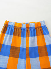 Baby shorts with elastic waistband in blue, orange, and brown plaid pattern.