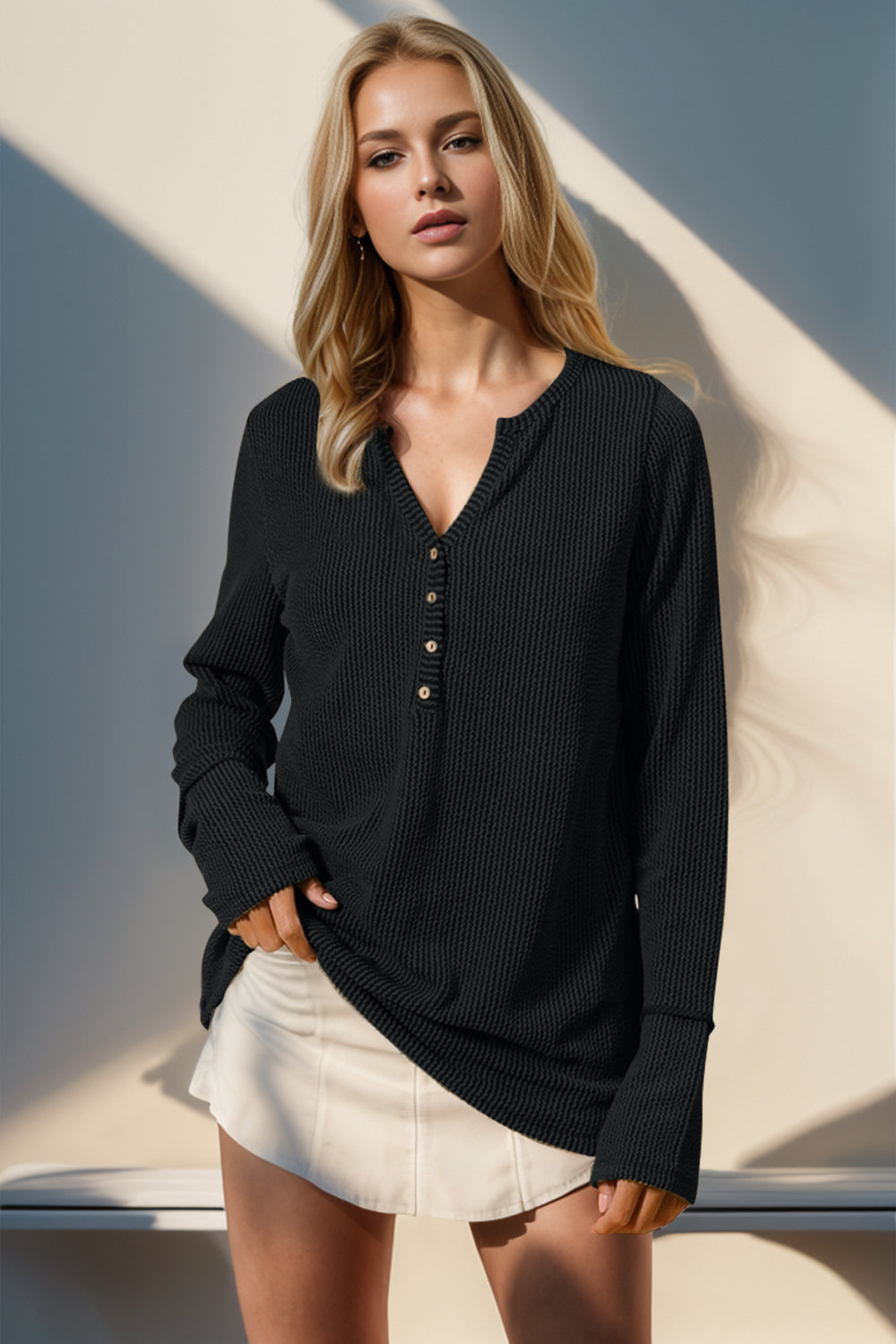 Black waffle knit henley shirt with button placket and thumbhole cuffs.