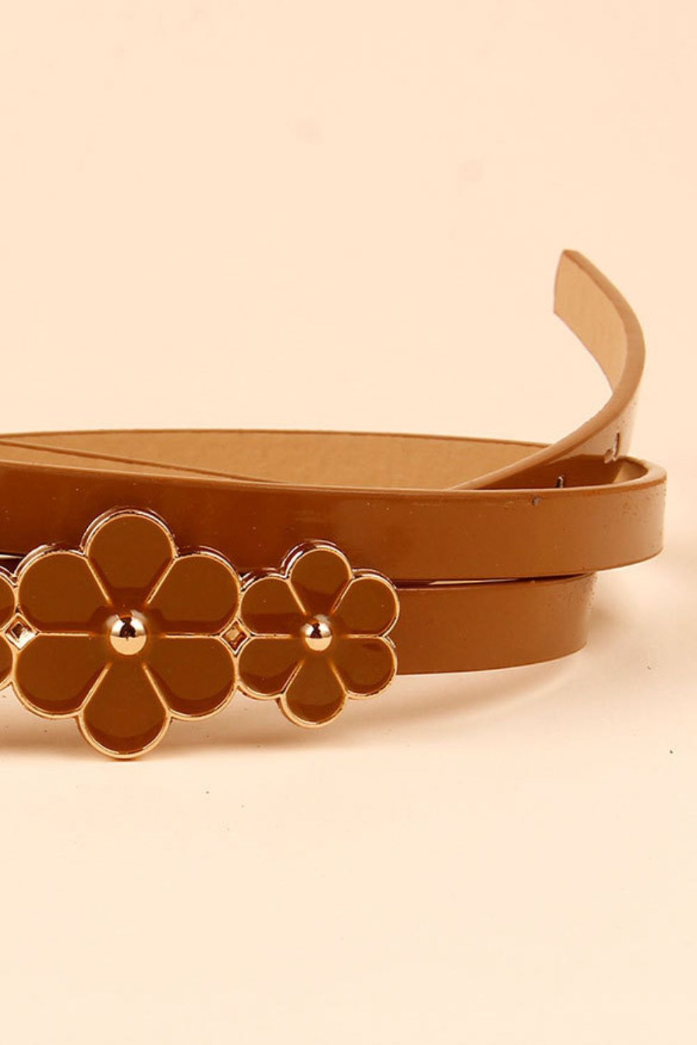 Caramel skinny belt with gold-tone flower embellishments.