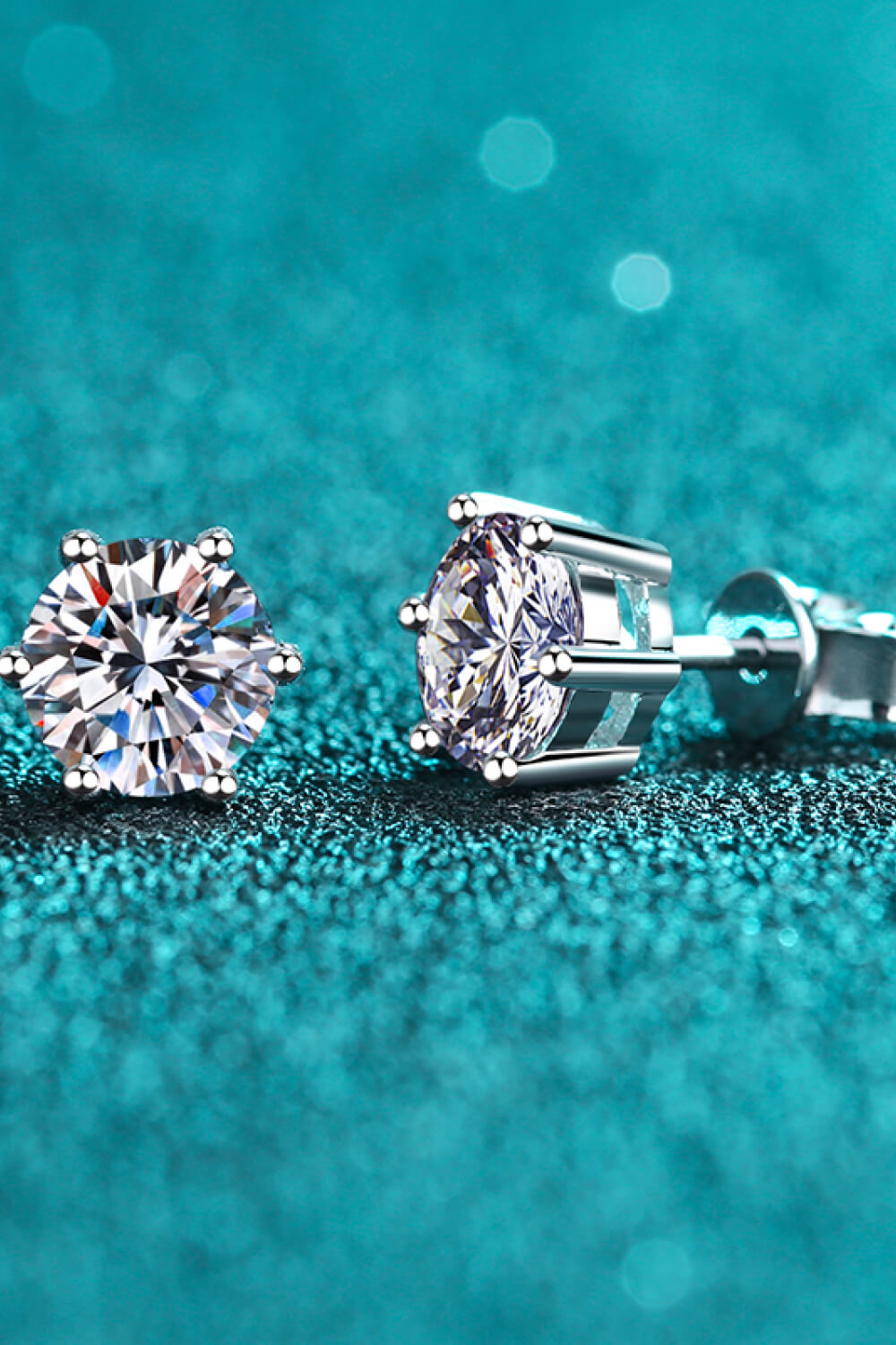 Silver six-prong moissanite stud earrings with brilliant cut stones.