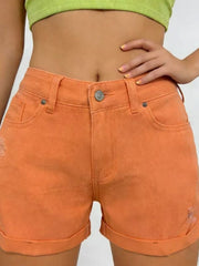 Orange-red cuffed denim shorts with distressed details and high waist.