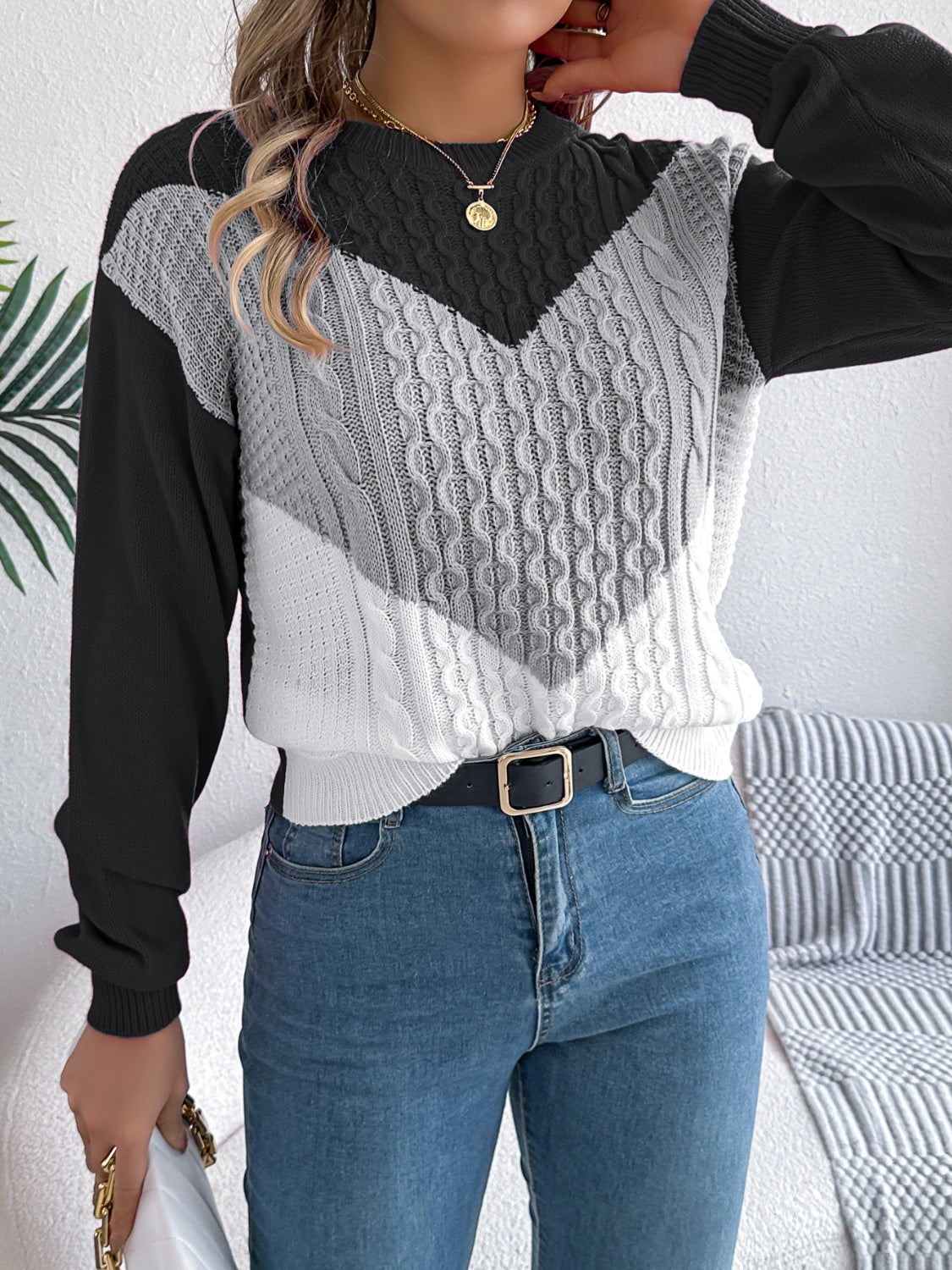 Chevron cable knit sweater with contrast gray, white, and black colorblock design.
