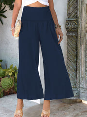 Navy smocked waist wide-leg trousers with a textured fabric, ankle length.