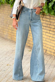 High-waisted palazzo flare denim jeans in medium wash, styled casually.