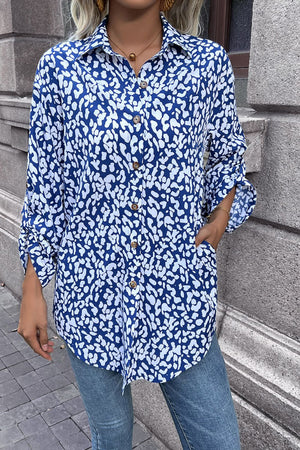 Sky blue oversized shirt with abstract spot print, buttoned front, and rolled sleeves.