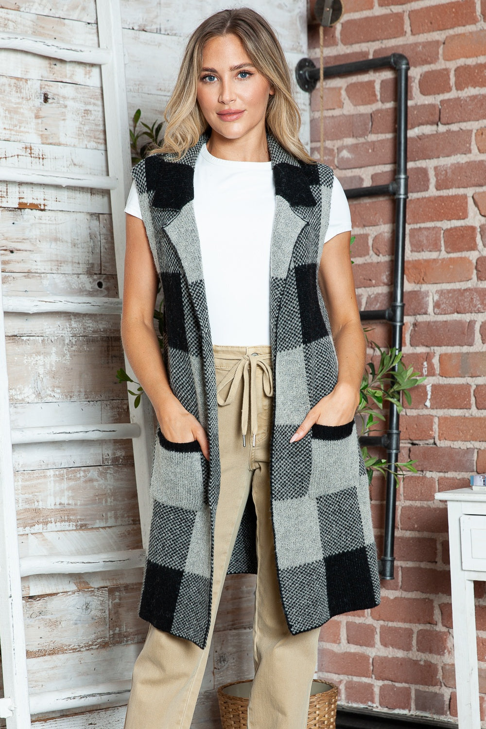 Geometric knit duster vest in black and tan checkered pattern with pockets.